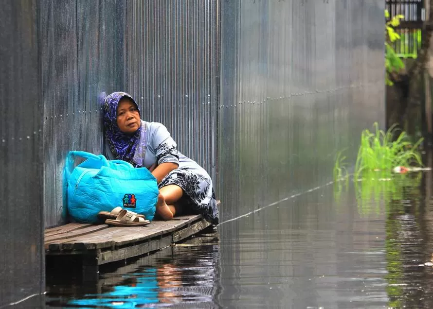 MENUNGGU PETUGAS: Perempuan paruh baya warga Jalan Mendawai VII terjebak banjir dan menunggu evakuasi oleh petugas. DENAR/KALTENG POS