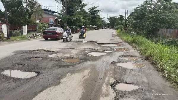 Penampakan Jalan berlubang di Jalan Rajawali km 7, dikeluhkan oleh warga karena berbahaya bagi pengguna jalan baik pengendara roda 2 maupun roda. Foto diambil Senin (9/5/2022).(FOTO : SYAHYUDI)