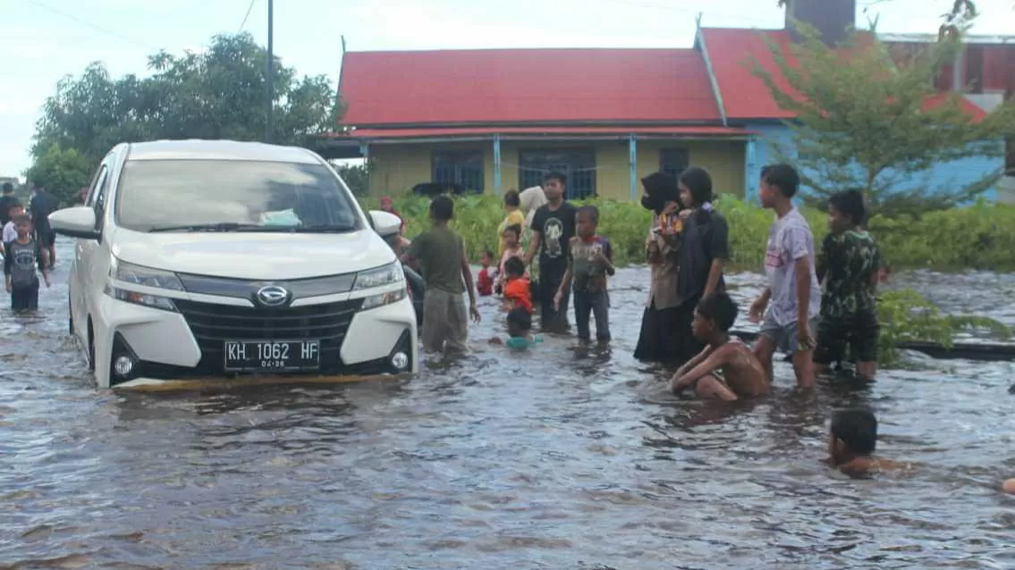 Kondisi banjir di Jalan Anoi dimanfaatkan anak-anak untuk bermain air di badan Jalan yang dilewati kendaraan, Sabtu (10/9)(HAFIDZ/PROKALTENG.CO)