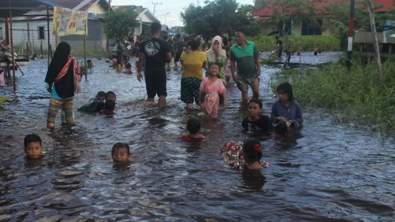 Kawasan Jalan Anoi yang terendam banjir dimanfaaatkan anak-anak untuk bermain air, Sabtu (12/9). (HAFIDZ/PROKALTENG.CO)