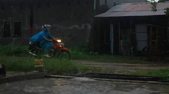 Pengendara motor melewati hujan deras saat melintas di salah satu ruas jalan di Kota Palangka Raya. (FOTO : HAFIDZ/PROKALTENG.CO)