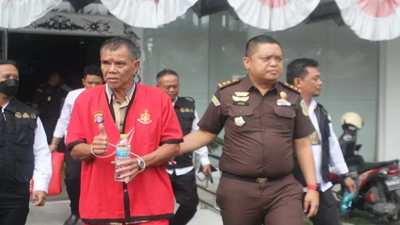 Tersangka Madi Goening Sius, digiring petugas usai berkas sudah dilimpahkan tahap dua di Kejati Kalteng, Senin (20/3) (HAFIDZ/PROKALTENG.CO)