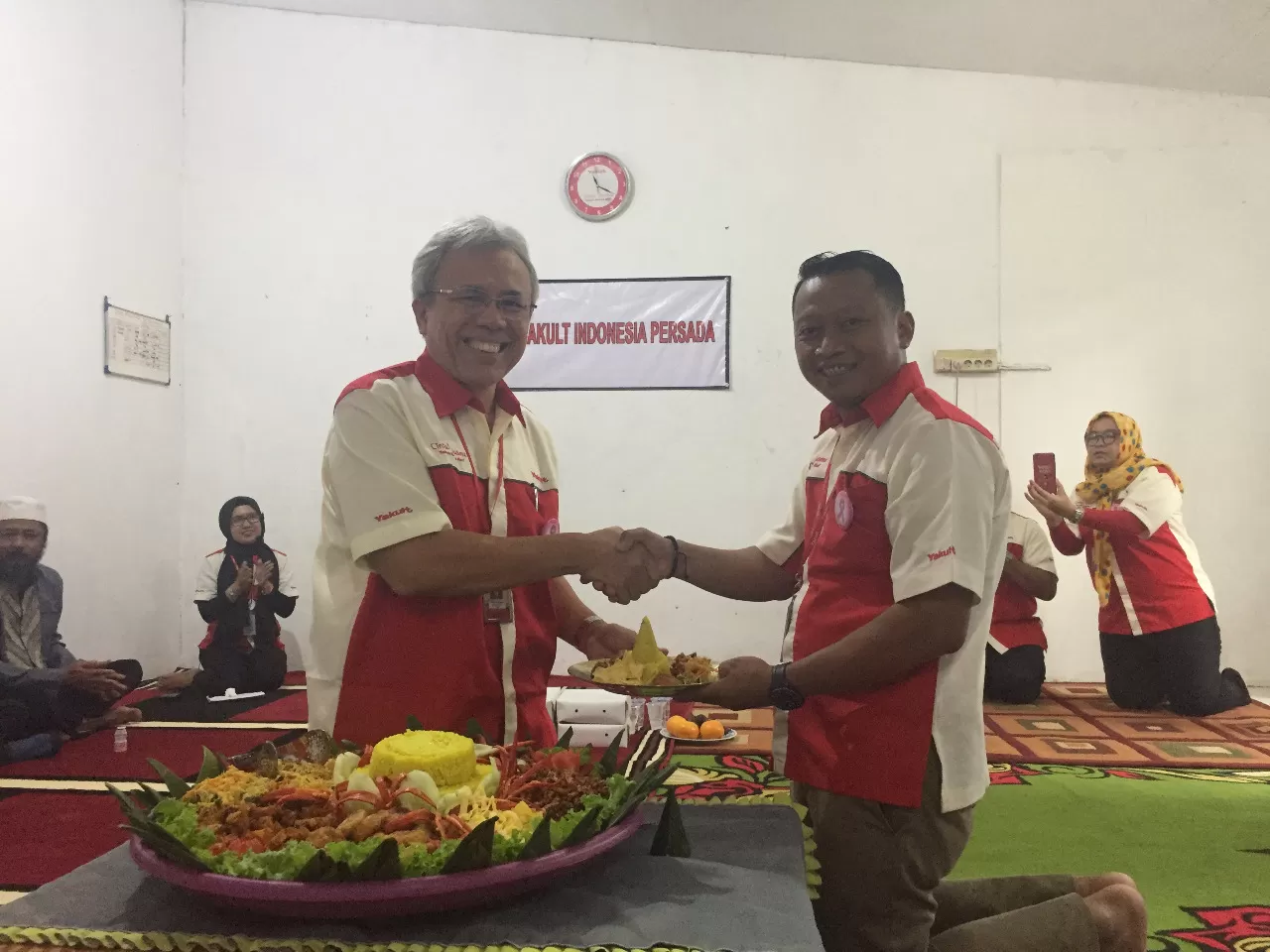 SELAMATAN: Senior Direktur PT Yakult Indonesia Persada Antonius Nababan (kiri) menyerahkan potongan tumpeng kepada Pimpinan Cabang Balikpapan Yuyun Durahman di kantor yang baru, Jalan Mulawarman, Balikpapan Timur.
