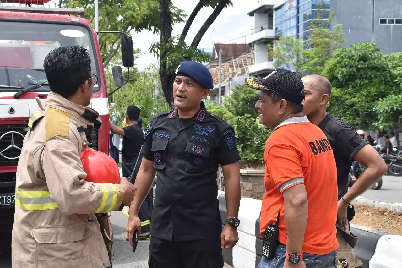 Komandan Satuan Brimob Polda Kaltim Kombes Pol. John Huntal S. Sitanggang, SIK (dua kiri) berkoordinasi dengan petugas pemadam kebakaran di lokasi kejadian.