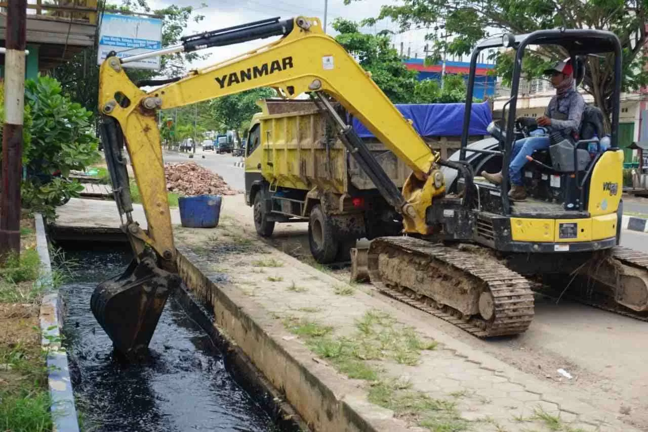 DIKERUK: Drainase di ruas Jalan APT Pranoto tampak dikeruk menggunakan excavator mini milik Dinas PU Kutim.