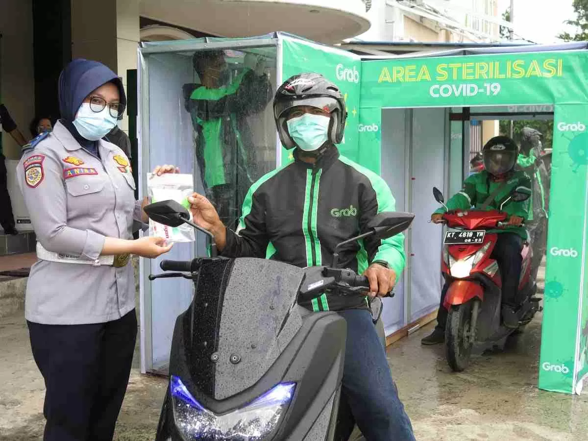 Pembagian masker, pembersih tangan (hand sanitisers) dan vitamin bagi mitra pengemudi GrabBike dan GrabCar di Balikpapan.