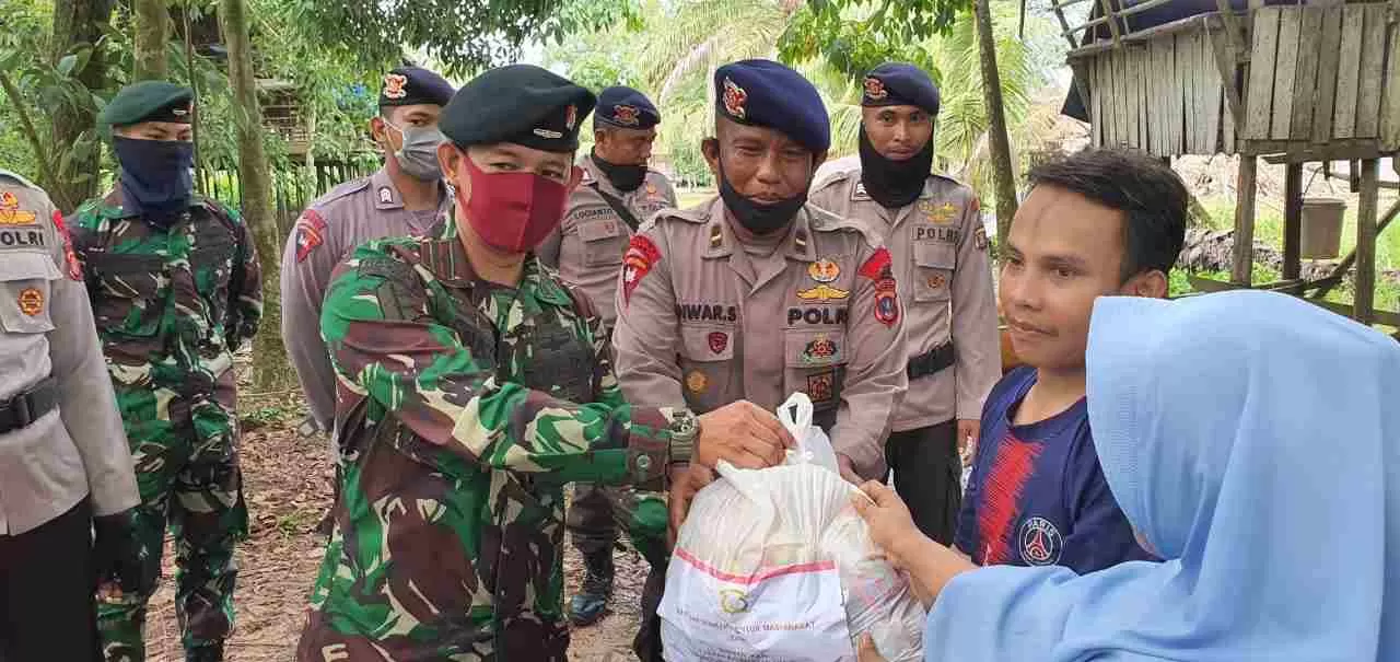 Anggota Brimob Polda Kaltim bersama anggota TNI menyerahkan sembako kepada warga tak mampu.