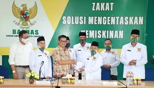 INFAK : Gubernur Kaltara, Dr H Irianto Lambrie saat menyerahkan infak pribadi kepada Ketua Baznas Kota Tarakan KH Zainuddin Dalila, Kamis (6/8).