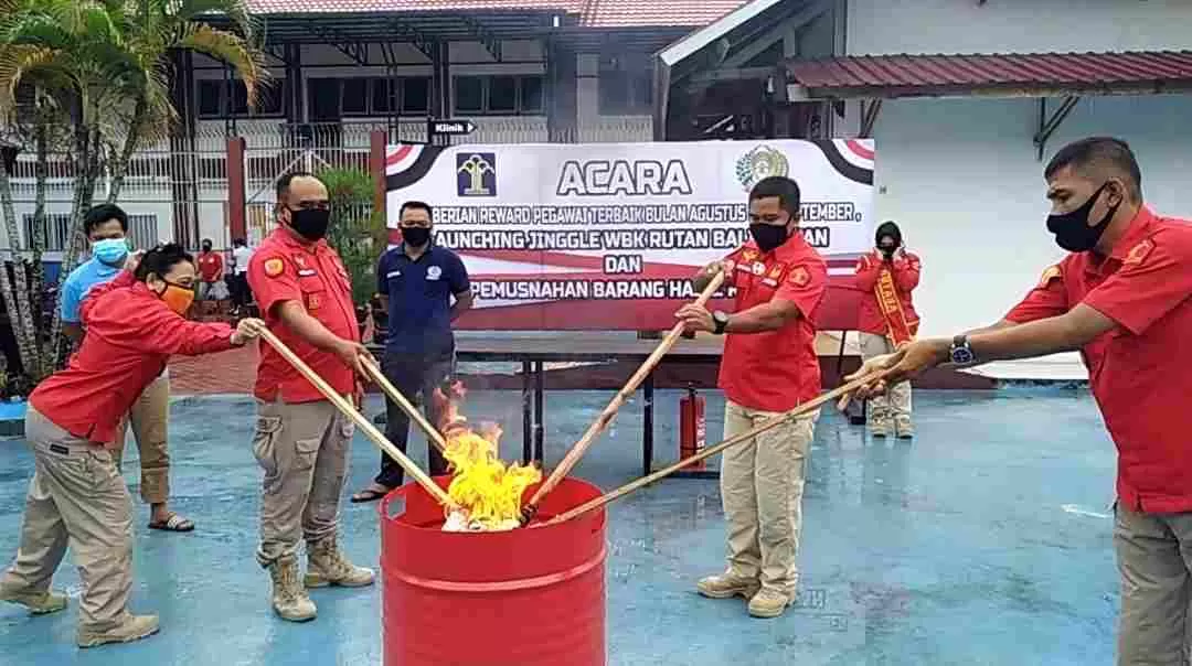 Kepala Rutan Klas II B Balikpapan Sopiana (dua kanan) dan anggotanya membakar barang hasil sitaan razia warga binaan, Sabtu (10/10). (foto: wawan/prokal)