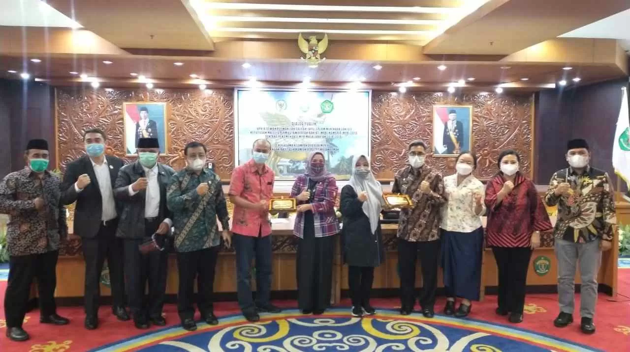 CENDERAMATA : Aji Mirni Mawarni (enam kanan) saat menyerahkan cenderamata ke Dekan Fakultas Hukum Unmul Mahendra Putra Kurni.