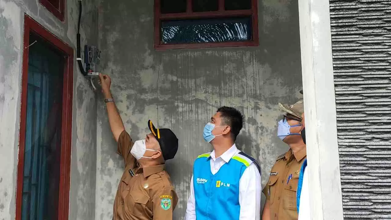 Bupati Edyanto (Kiri) bersama Ari Tirta (dua kiri) saat proses penyalaan kWh meter di rumah warga pada, Senin (12/4).
