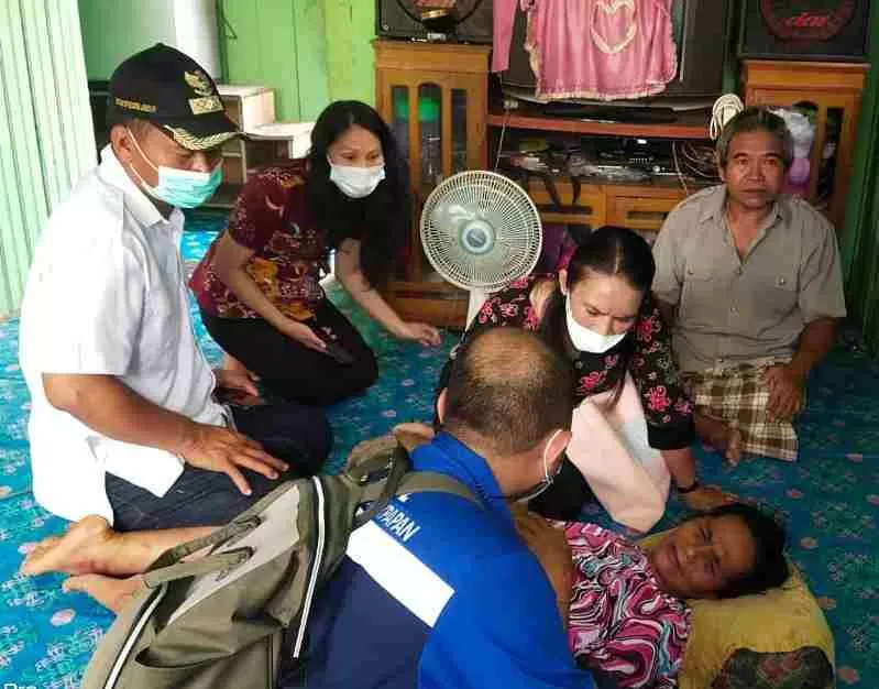 BENTUK KEPEDULIAN: Tim Comdev PT Indexim Coalindo menyerahkan bantuan kepada Kades Pengadan Syarifuddin Jabir. Tim medis dari perusahaan juga tampak memeriksa kondisi warga terdampak banjir.