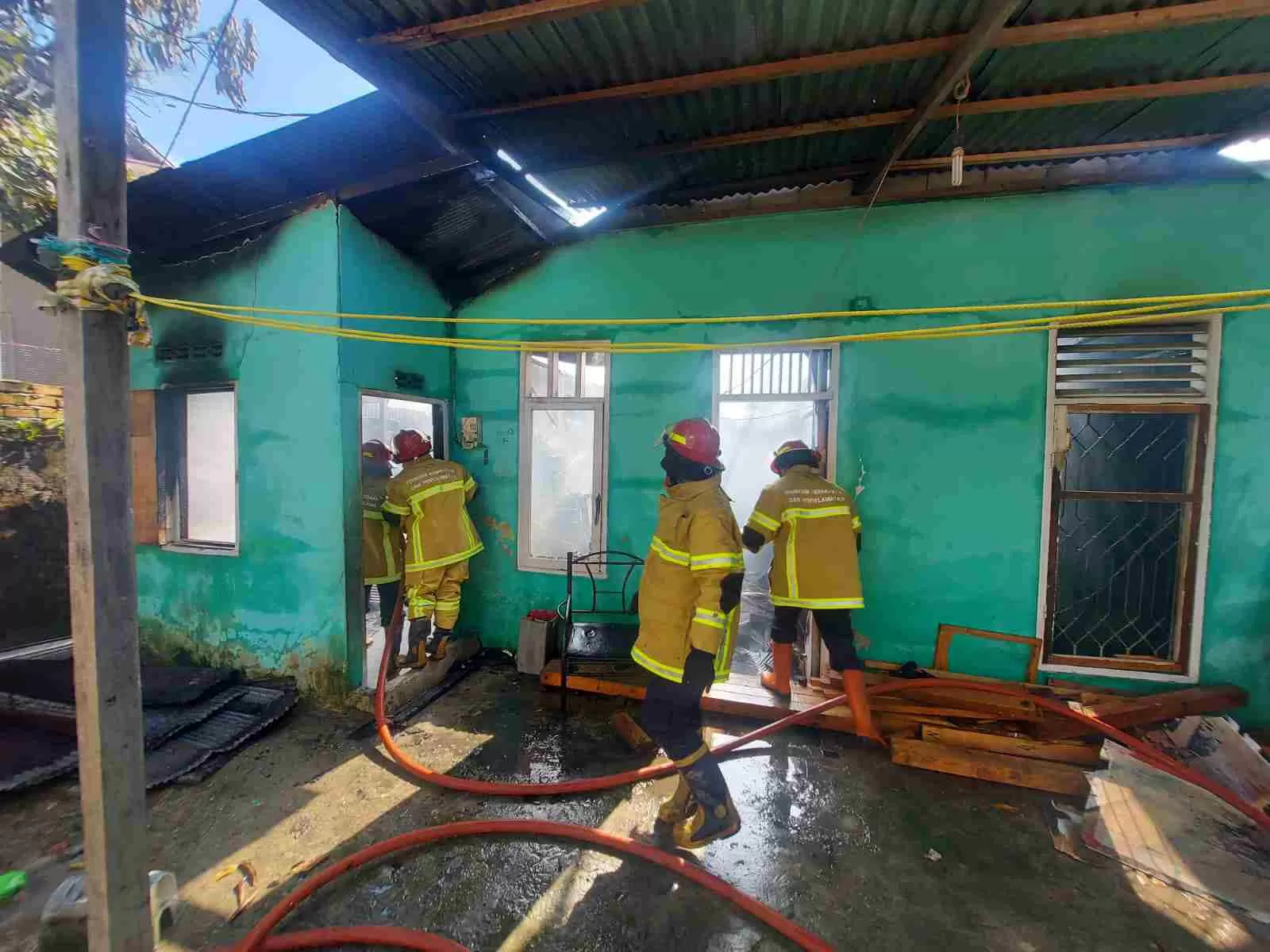 Petugas BPBD Kota Balikpapan berjibaku memadamkan api yang membakar rumah warga di RT 56, Kelurahan Gunung Bahagia, Balikpapan Selatan.