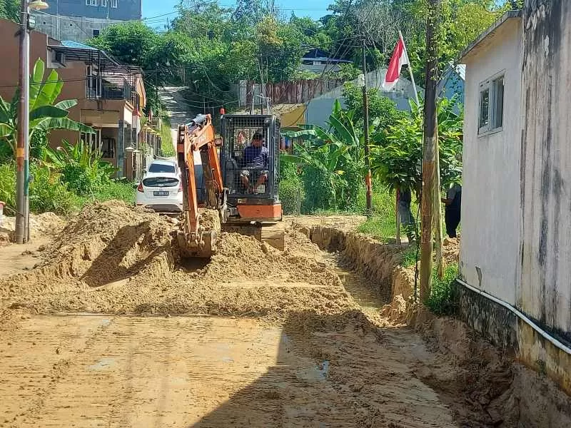 Unit ekskavator dikerahkan ntuk mengeruk material pasir dan lumpur bekas pengupasan lahan yang membanjiri jalanan dan drainase di RT 59, Sumber Rejo, Balikpapan Tengah.