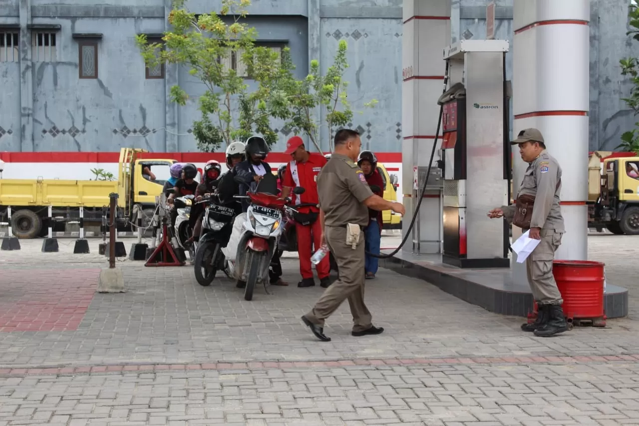 AWASI SPBU: Petugas Satpol PP saat mengawasi pembelian BBM di SPBU Jalan Mulawarman, Rabu (1/1).