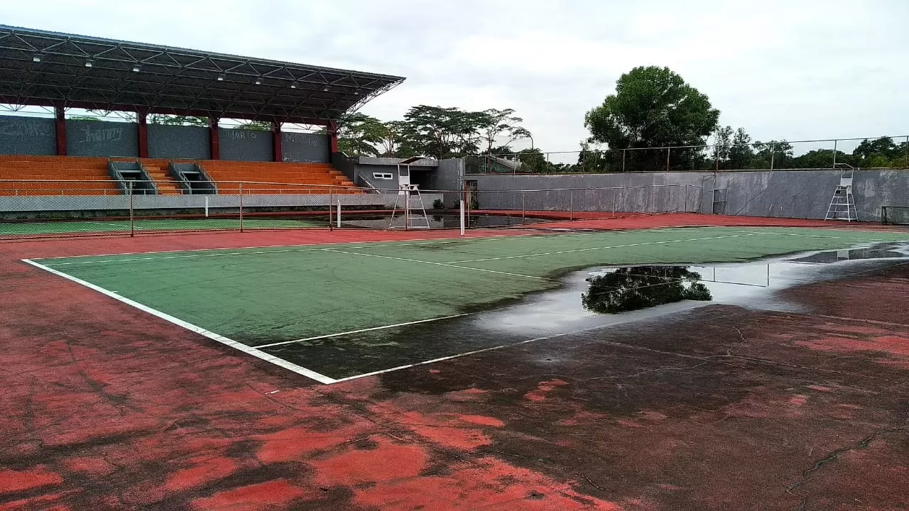 TAK TERAWAT: Tampak genangan air pada salah satu sisi lapangan tenis outdoor di kompleks sport center.