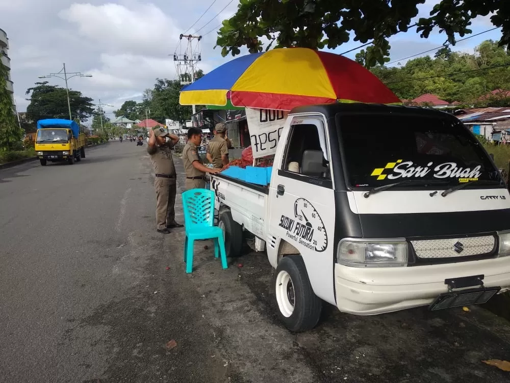 DIPERINGATI: Petugas Satpol PP Tarakan saat memberi teguran kepada pedagang buah musiman di Jalan Mulawarman, kemarin (17/1).