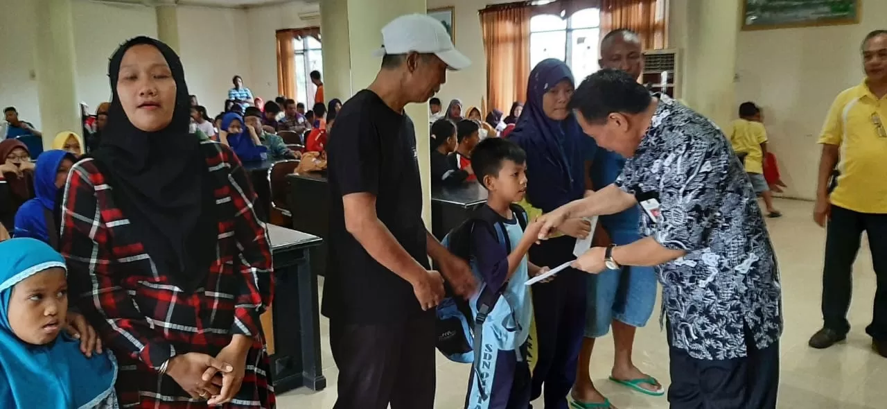 SALURKAN BANTUAN PENDIDIKAN: Kepala Disdikbud Tarakan Tajuddin Tuwo membagikan bantuan uang tunai kepada siswa terdampak kebakaran, Jumat (31/1).