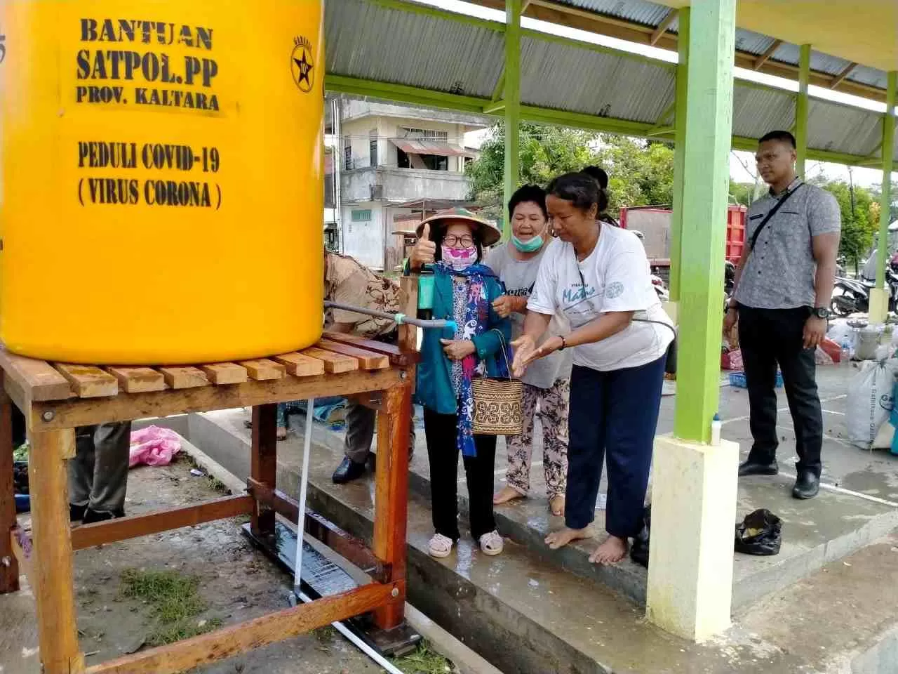 FASILITAS CUCI TANGAN: Sejumlah warga tampak memanfaatkan fasilitas cuci tangan yang disediakan Satpol PP Kaltara di Pasar Induk Tanjung Selor, kemarin (2/4).