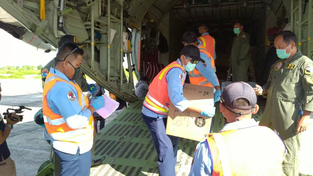 ALAT PELINDUNG DIRI: Awak pesawat Hercules menurunkan paket APD dan masker yang dikirim dari Jakarta, untuk para petugas di rumah sakit rujukan di Kaltara, Sabtu (4/4).