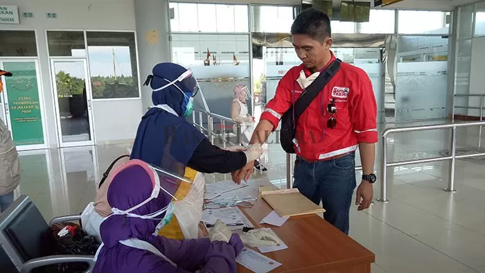 BATASI PERJALANAN ORANG: Petugas kesehatan memeriksa penumpang yang baru tiba di Bandara Juwata Tarakan, pada 8 Mei lalu.