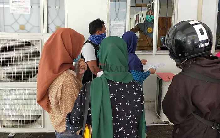 MASUK KERJA: Pegawai Disdukcapil Tarakan melayani pembuatan dokumen kependudukan masyarakat melalui jendela, Selasa (2/6).