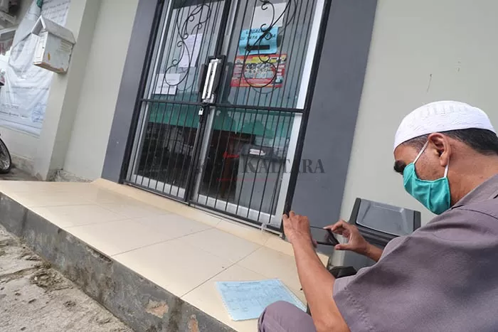 LAYANAN TUTUP: Salah seorang warga saat mengurus berkas secara online di depan kantor Disdukcapil Bulungan, Selasa (2/6).