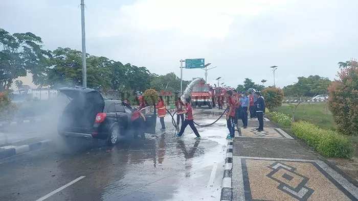 MOBIL TERBAKAR: Petugas PKP-PK memadamkan api yang membakar mobil di area Bandara Juwata Tarakan, Senin (20/7).