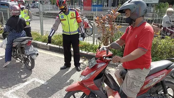 PROTOKOL KESEHATAN: Selain sosialisasi adanya marka jarak di perempatan lalu lintas, personel Satlantas Polres Tarakan juga memberikan masker pada pengendara, Sabtu (25/7).
