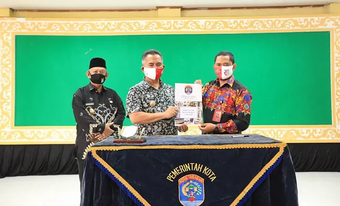 HIBAHKAN ASET: Wali Kota Tarakan Khairul (tengah) menyerahkan berita acara penyerahan aset kepada Ketua KPU Tarakan, Nasruddin, pekan lalu.