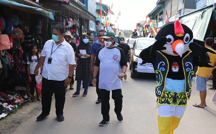 DAYA TARIK: Maskot Pilkada Kaltara Si Ega (kanan) disambut antusias masyarakat di Desa Mansalong, Kabupaten Nunukan.