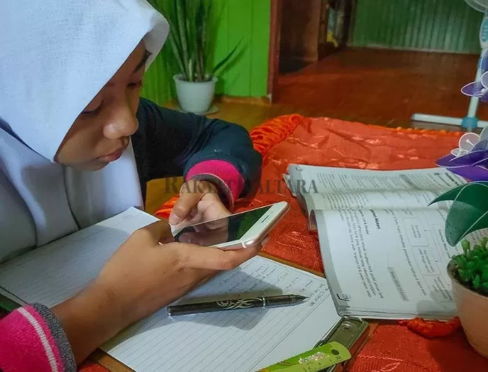 DARING: Wahyuni salah satu siswa SMAN 1 Tanjung Selor kelas XII saat belajar daring di rumahnya, Kamis (17/9).