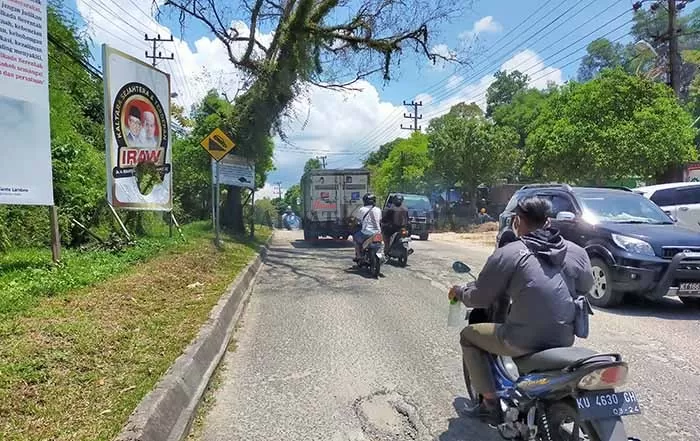 RUSAK: Baliho IRAW yang dipasang di Jalan Pangeran Diponegoro, Gunung Belah, terlihat robek.
