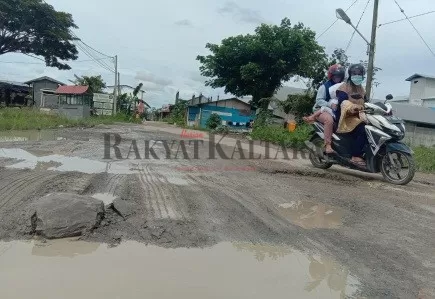 BUTUH PERBAIKAN: Warga saat melintasi di Jalan Niaga Tanjung Selor yang mengalami kerusakan.
