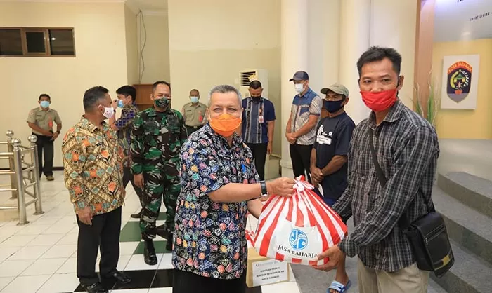 SALURKAN BANTUAN: Sekda Tarakan Hamid Amren (kiri) menyerahkan bantuan kepada perwakilan warga terdampak musibah tanah longsor di Kantor Wali Kota Tarakan, Kamis (22/10) lalu.