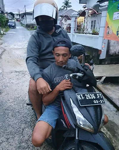 DIRINGKUS: Pelaku IM saat duduk dibawah sepeda motor usai diamankan di Jalan Hang Tuah, Kelurahan Selumit, Tarakan Tengah.