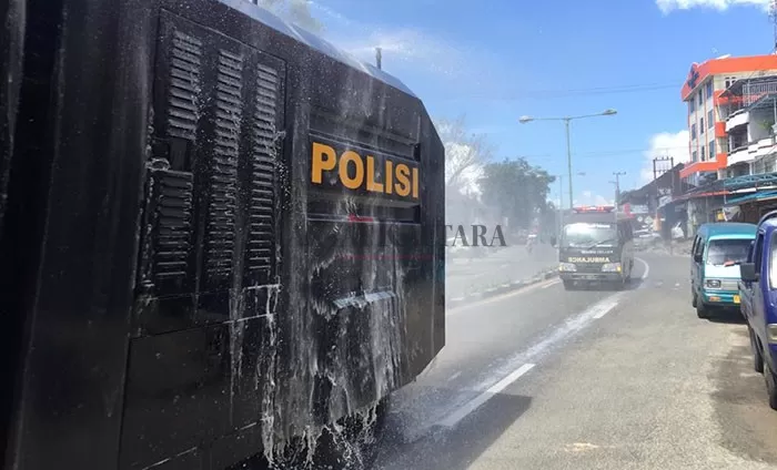 PENYEMPROTAN DISINFEKTAN: Pihak kepolisian melakukan penyemprotan disinfektan diruas jalan di Tarakan, Kamis (17/12).