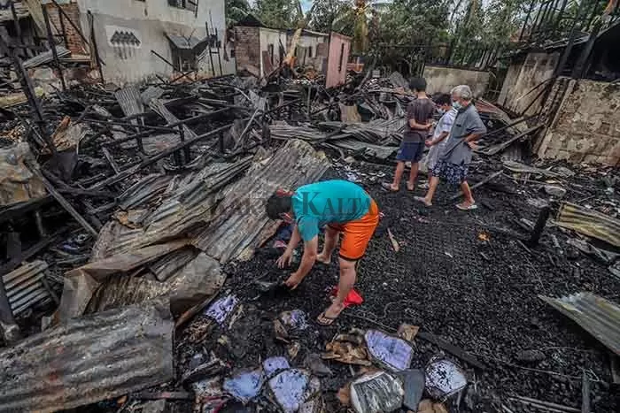 TINGGAL PUING: Keluarga pemilik rumah yang menjadi korban kebakaran rumah mencari barang berharga di tengah puing sisa kebakaran, Rabu (10/2).