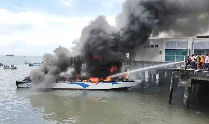 HANGUS: Petugas berusaha memadamkan api yang membakar speedboat SB Dewa Sebakis Sakti III kemarin (28/3).