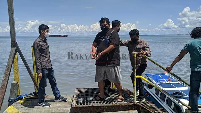 DIGIRING KE TARAKAN: Tersangka ER (baju hitam) saat tiba di Pelabuhan Tengkayu II Tarakan, usai diamankan di Kabupaten Malinau, Kamis (24/6).