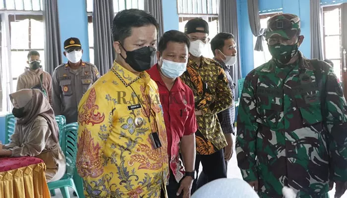 MONITORING: Bupati KTT Ibrahim Ali (batik kuning) saat mengunjungi pelaksanaan vaksinasi di dua desa di Kecamatan Sesayap Hilir, Kamis (29/7).