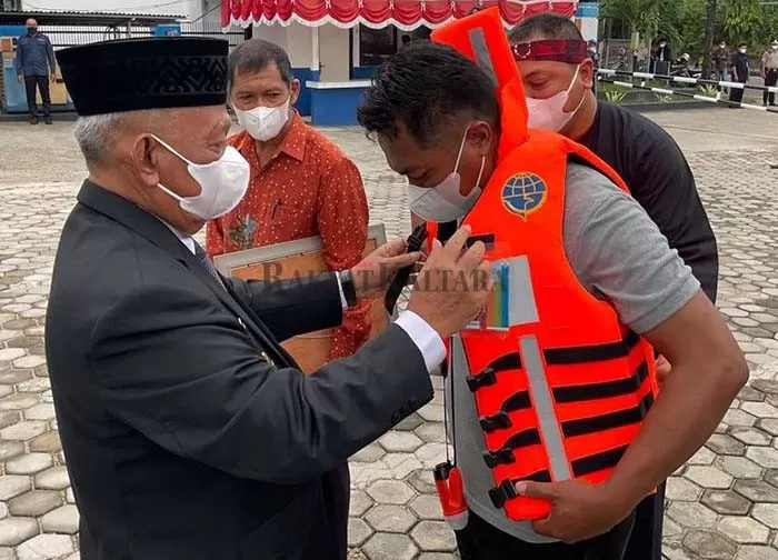 MINIM GUNAKAN LIFE JACKET: Wakil Wali Kota Tarakan Effendhi Djuprianto saat memasangkan life jacket pada nelayan di Kantor KSOP Tarakan, Jumat (17/9).