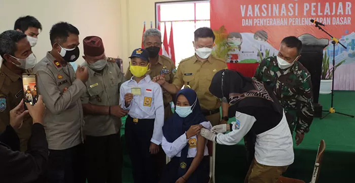 BERJALAN LANCAR: Bupati KTT Ibrahim Ali (tiga dari kanan) melihat penyuntikan vaksin terhadap pelajar SMP, Senin (20/9).