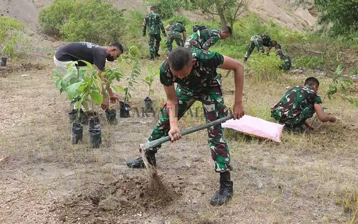 HIJAUKAN PERBUKITAN: Personel Satgas Pamtas RI–Malaysia Yonarmed 18/Komposit Buritkang menanam buah endemik, Minggu (10/10).