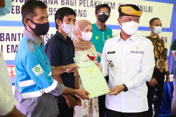 DISERAHKAN: Bupati Ibrahim Ali (kanan) menyerahkan langsung sertifikat tanah kepada warga di Desa Bebatu, Kecamatan Sesayap Hilir, kemarin (27/10).