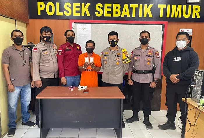 KURIR SABU: Tersangka (baju orange) diapit personel Polsek Sebatik Timur yang diamankan karena dugaan kepemilikan sabu, Rabu lalu (10/11).