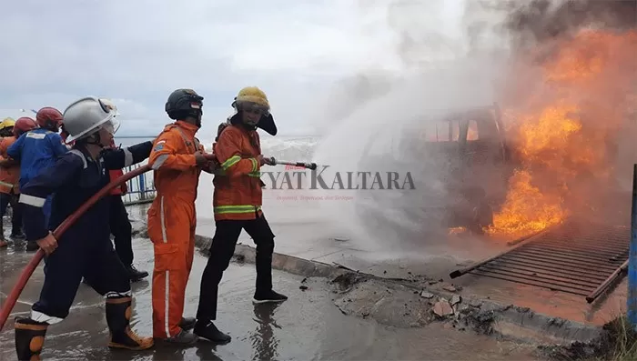 PADAMKAN API: Petugas PMK berupaya memadamkan api yang membakar mobil pickup di Pelabuhan Tengkyu I Tarakan, Minggu pagi (12/12).