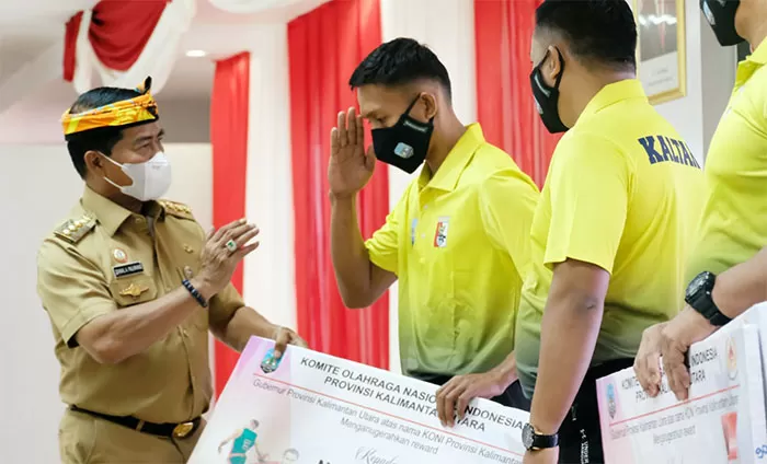 PEMBERIAN BONUS: Atlet berprestasi di ajang PON XX Papua lalu menerima bonus yang diserahkan Gubernur Kaltara Zainal Arifin Paliwang, kemarin (28/12).