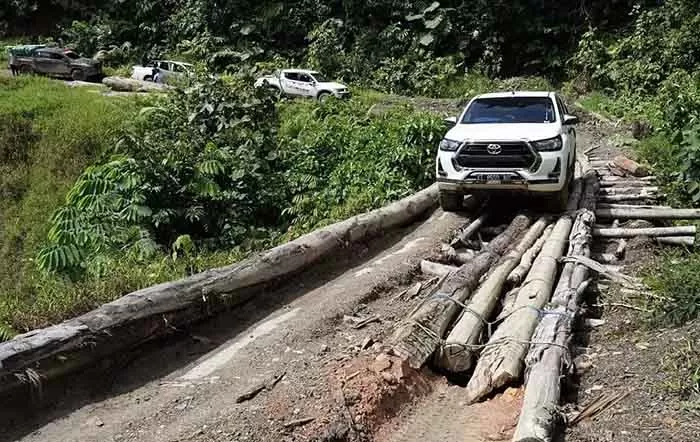 MEMPRIHATIKAN: Kondisi jembatan yang menggunakan kayu log sangat membahayakan bagi kendaraan yang melintas.