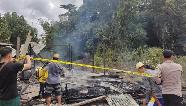 SISA PUING: Satu unit rumah yang terbakar di Desa Pimping telah dipasang garis polisi.